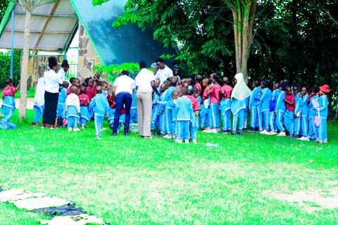 A large group of pupils gathered under a shelter