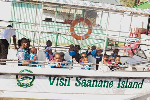 Pupils in life jackets waving from the Saanane Island boat